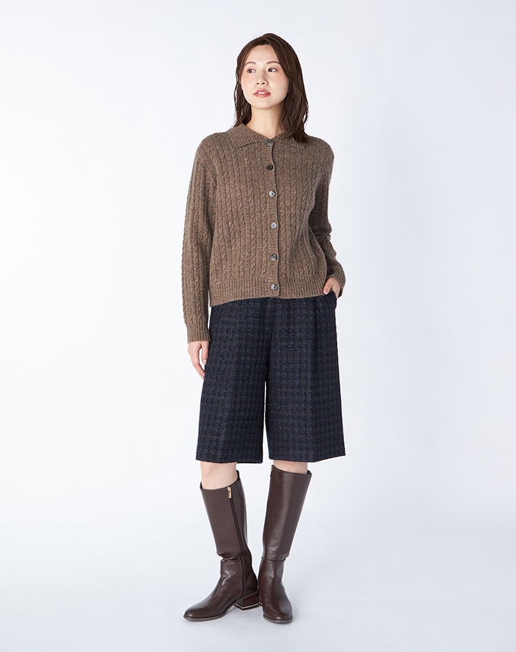 スワローケーブルニットカーディガンを身に纏った女性