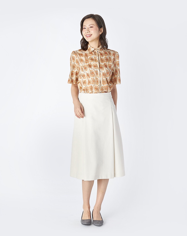 オレンジのマーブル柄のシャツを身に着けた女性