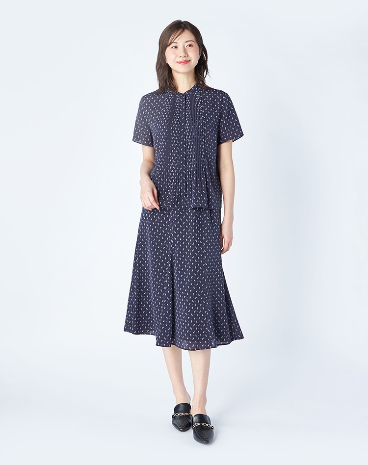 ネイビーのペイズリー柄セットアップを身に着けた女性