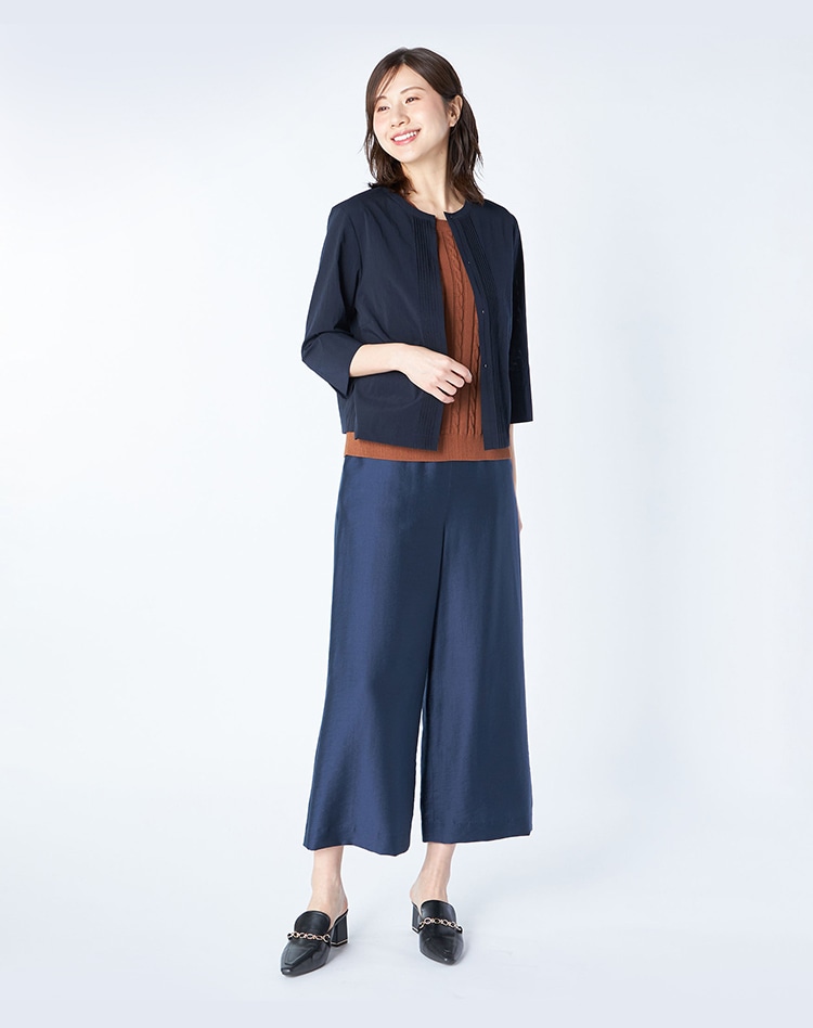 ネイビーのジャケットとネイビーのパンツを身に着けた女性