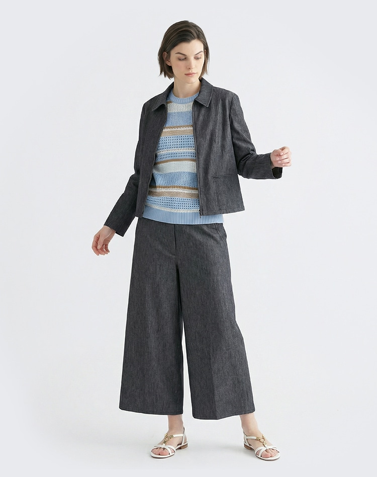 ダークグレーのセットアップ、ブルーのボーダーのニットを身に着けた女性