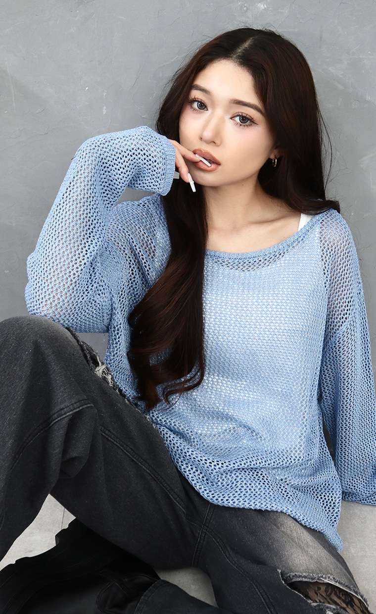 透かし編みニットとデニムワイドパンツを着用の女性