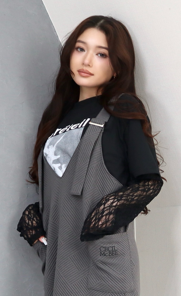 フロントプリントプルオーバーとジャンパースカートを着用の女性