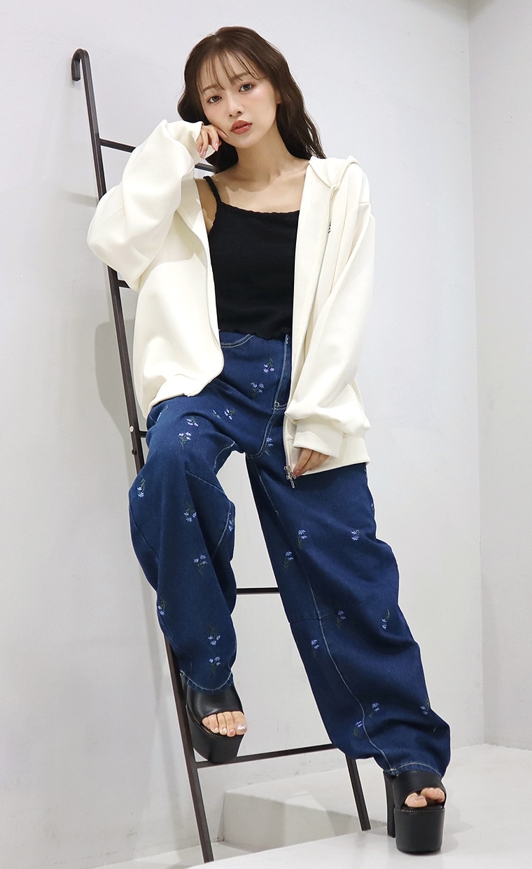 ジップアップパーカーと刺繍カーブパンツを着用の女性