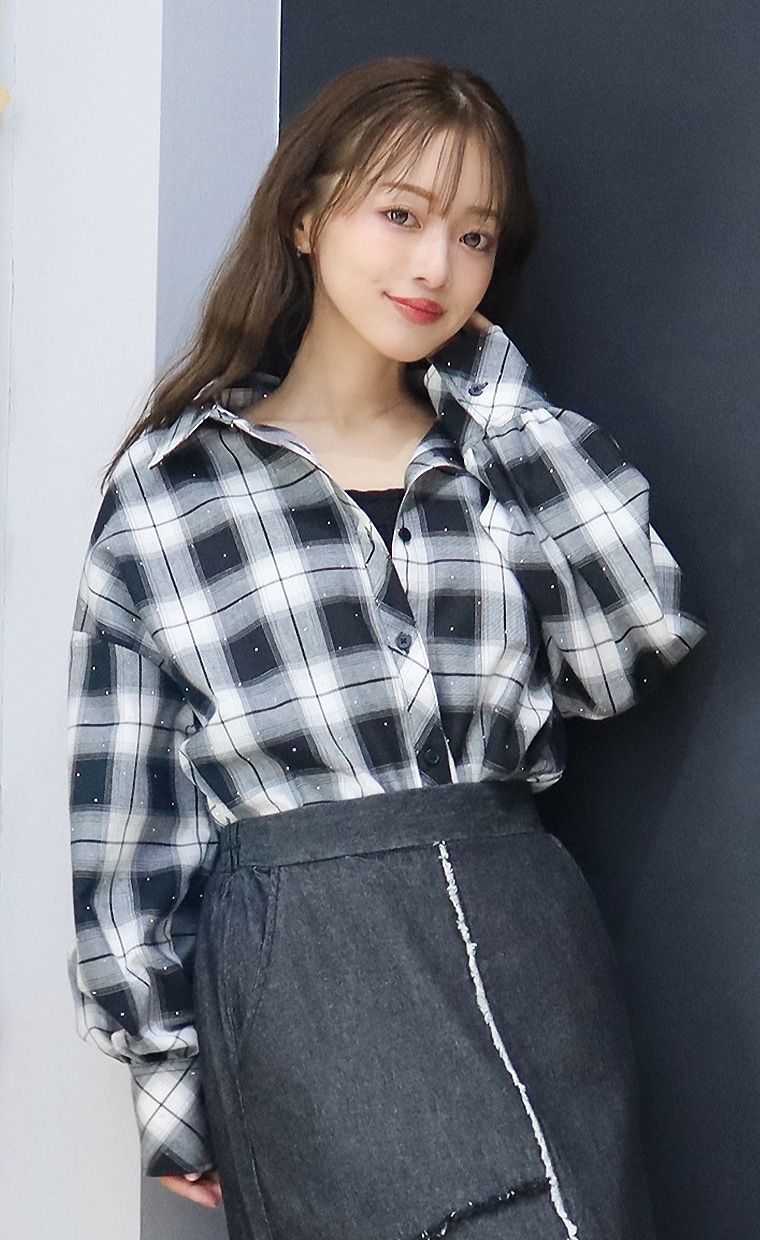 チェックシャツとフリンジ切替スカートを着用の女性