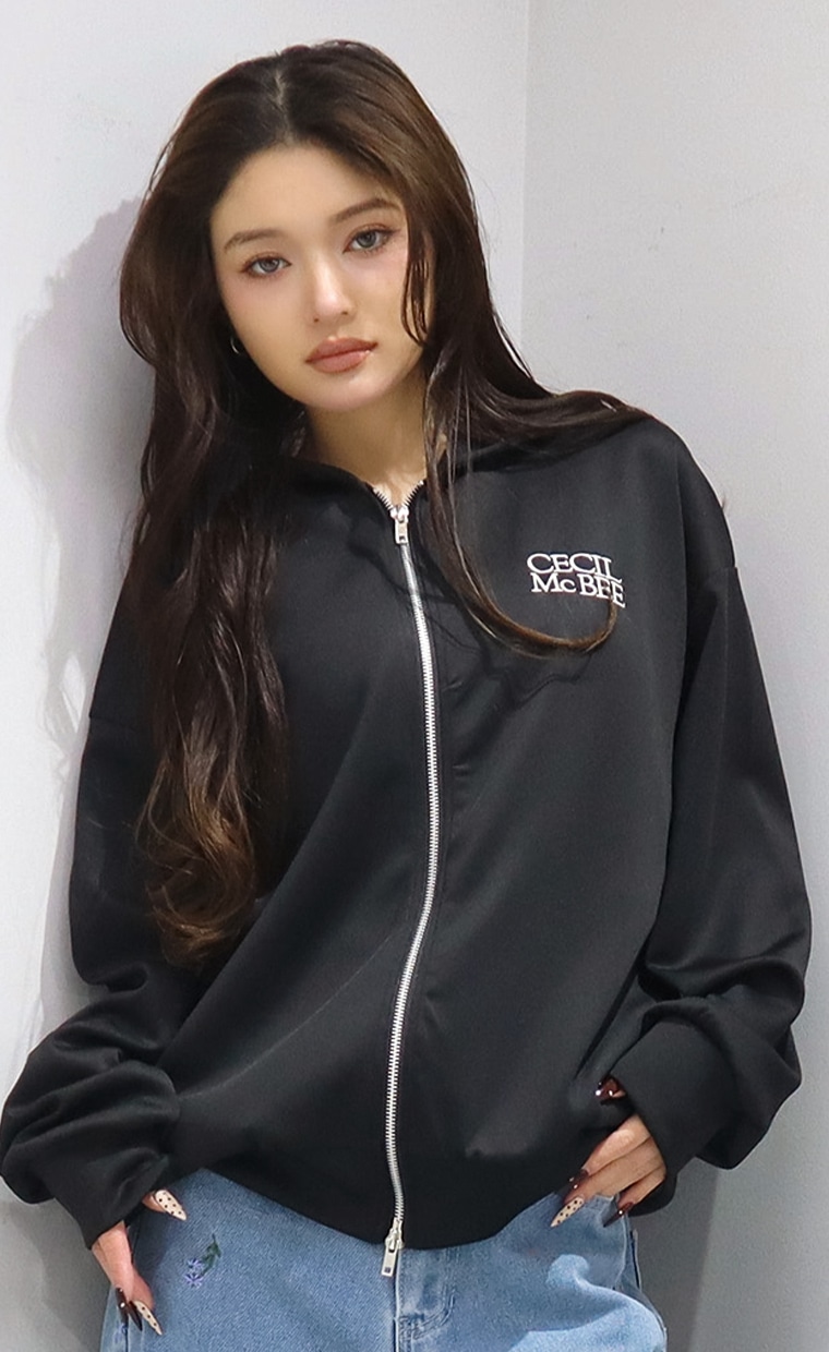 ジップアップパーカーとカーブパンツを着用の女性