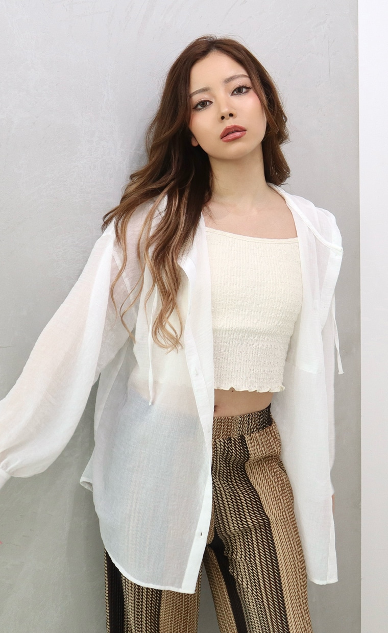 フーディーシャツとグラデーション風プリーツストレートパンツを着用の女性"