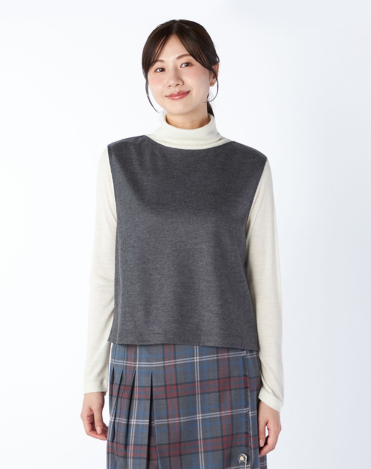 グレーの無地のベストを身に着けた女性