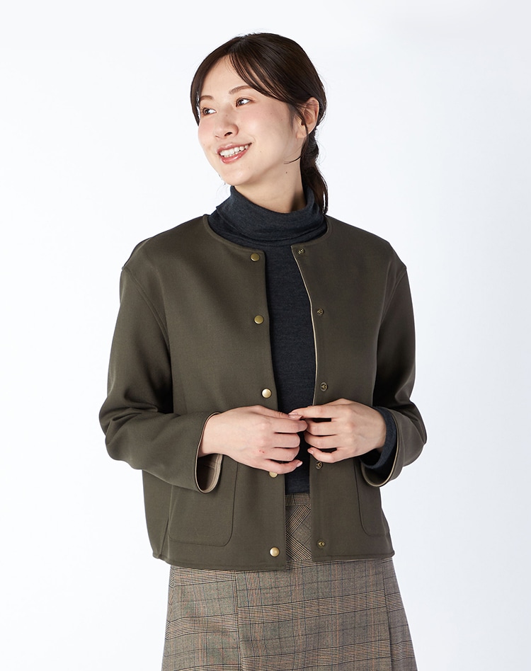 ダークグリーンの無地のジャケットを身に着けた女性