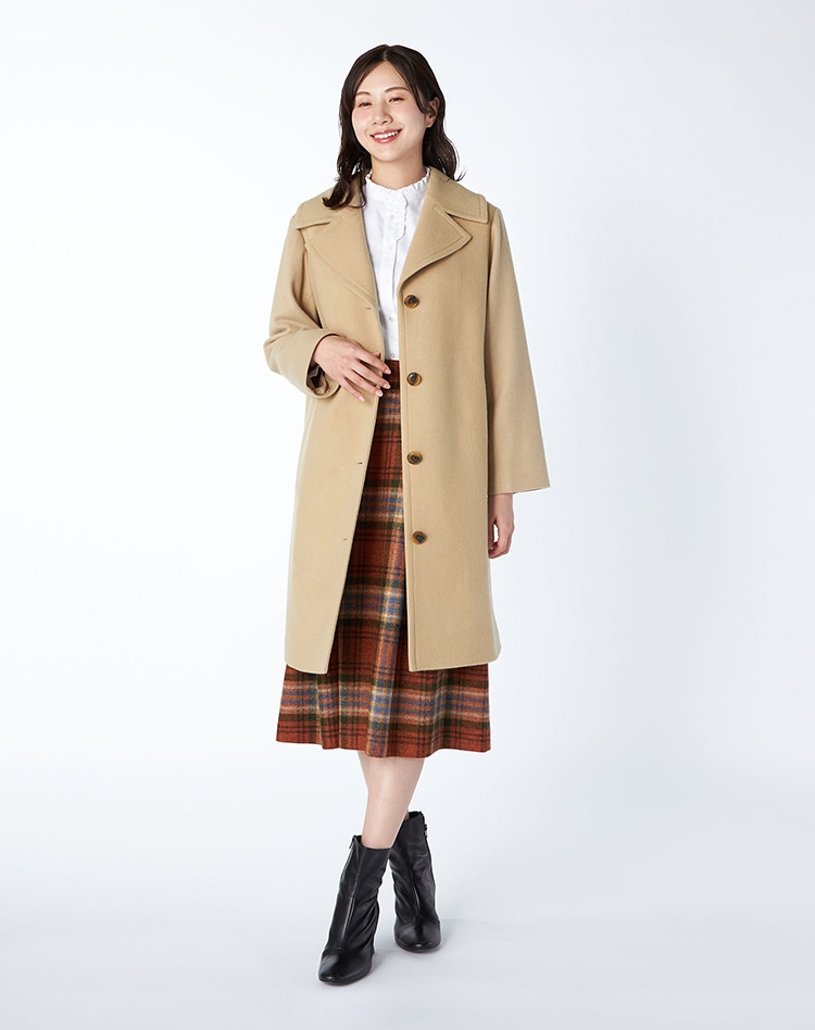 ベージュのロングコートを身に着けた女性