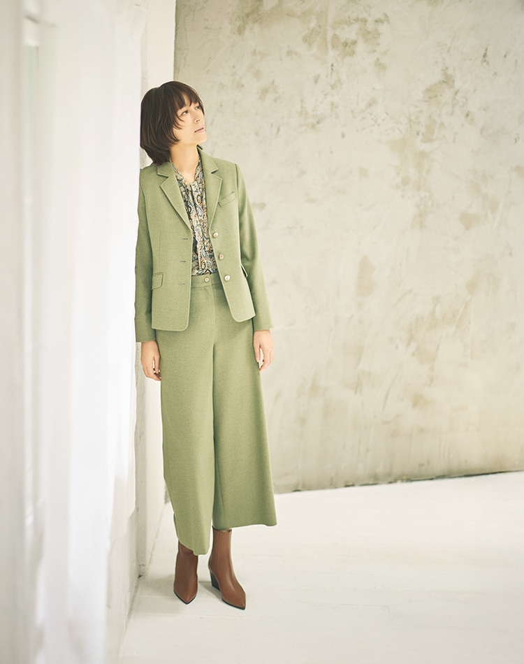 グリーンの無地のジャケットを身に着けた女性