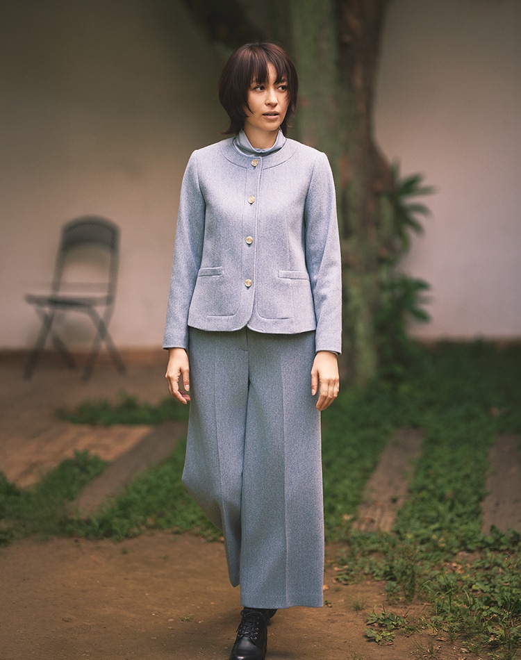 ブルーのジャケット、ブルーのパンツを身に着けた女性