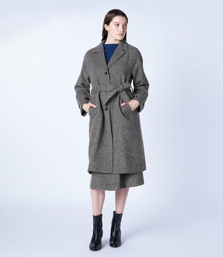 グレーのウールドビーロングコートを着た女性