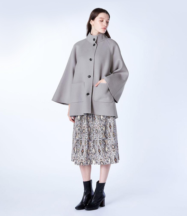 グレーのライトリバーコートを着た女性