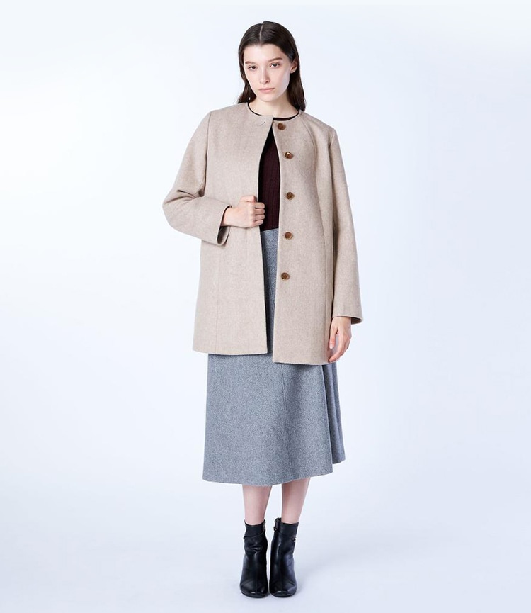 ベージュのウールビーバーノーカラーコートを着た女性