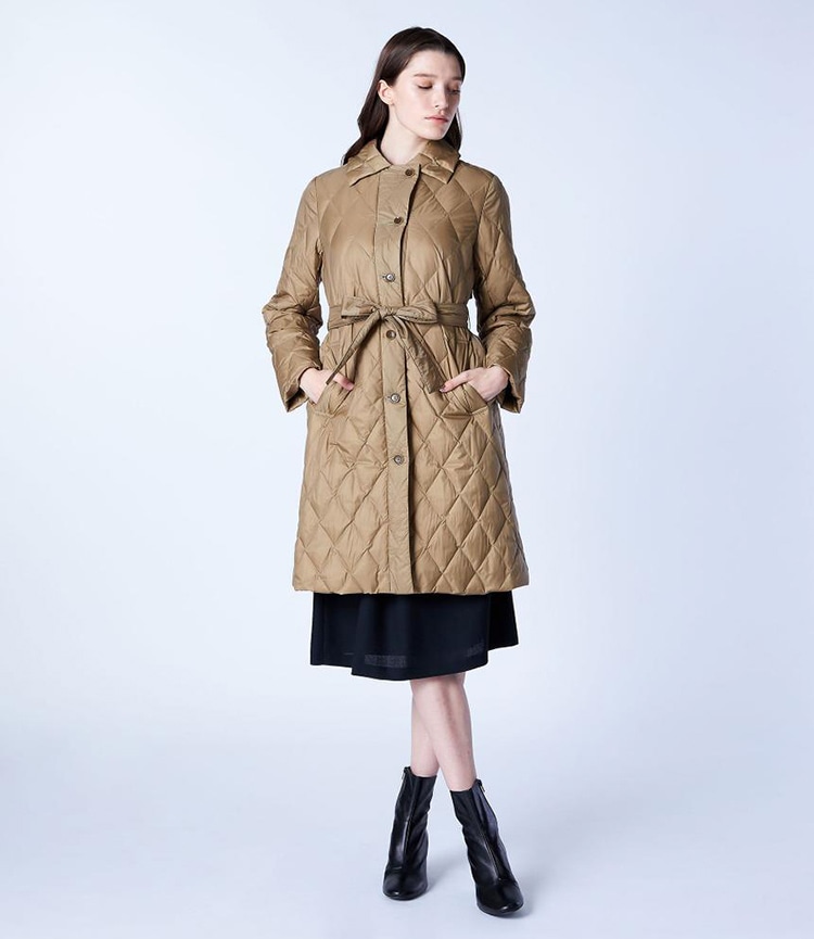 ベージュのステラダウンコートを着た女性