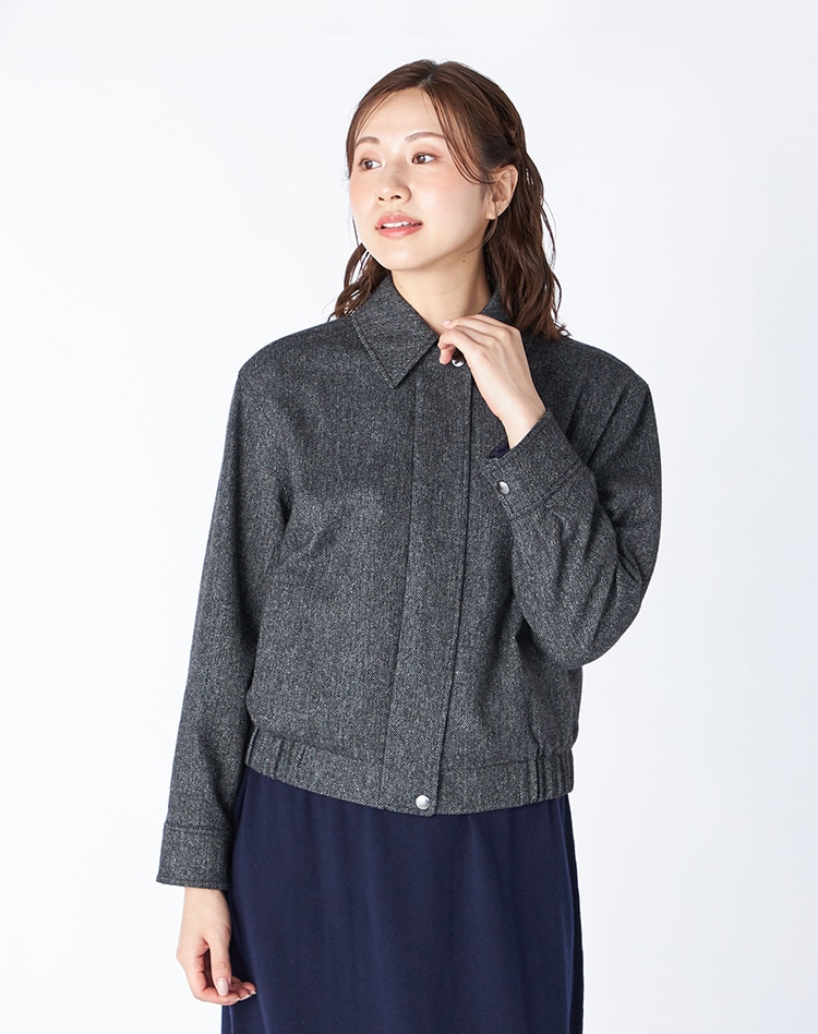 	チャコールグレーのジャケットを身に纏った女性