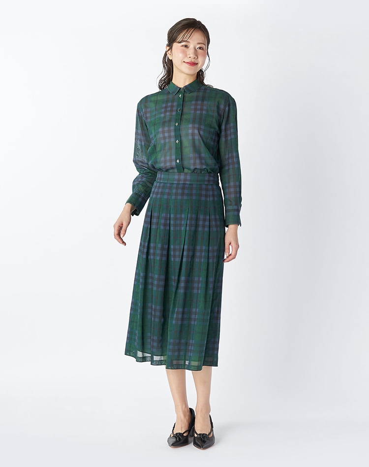 グリーンのチェック柄のセットアップを身に着けた女性