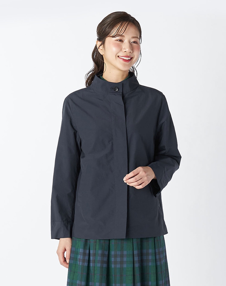 ネイビーのジャケットとチェックのスカートを身に着けた女性