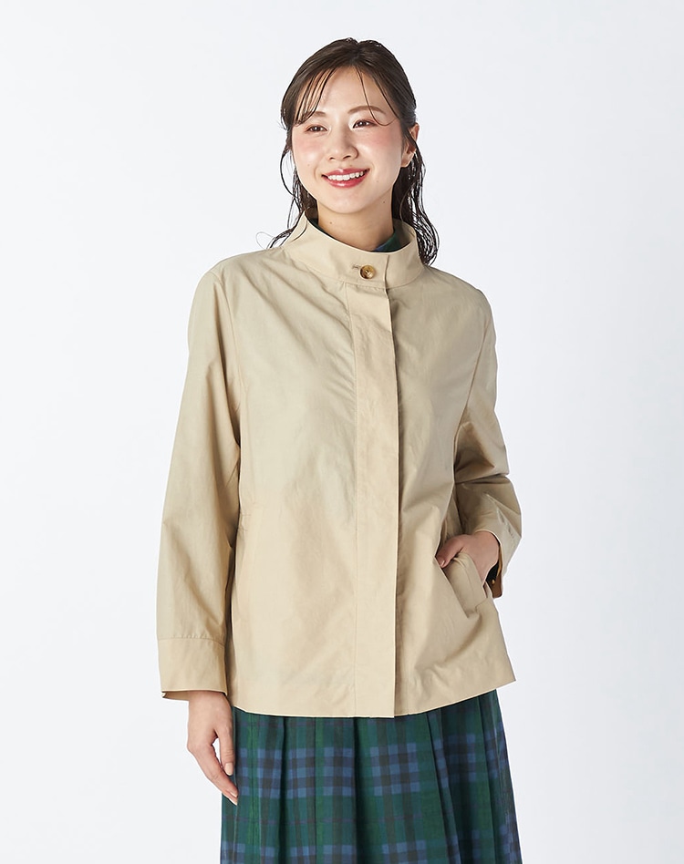 ベージュのジャケットとチェックのスカートを身に着けた女性