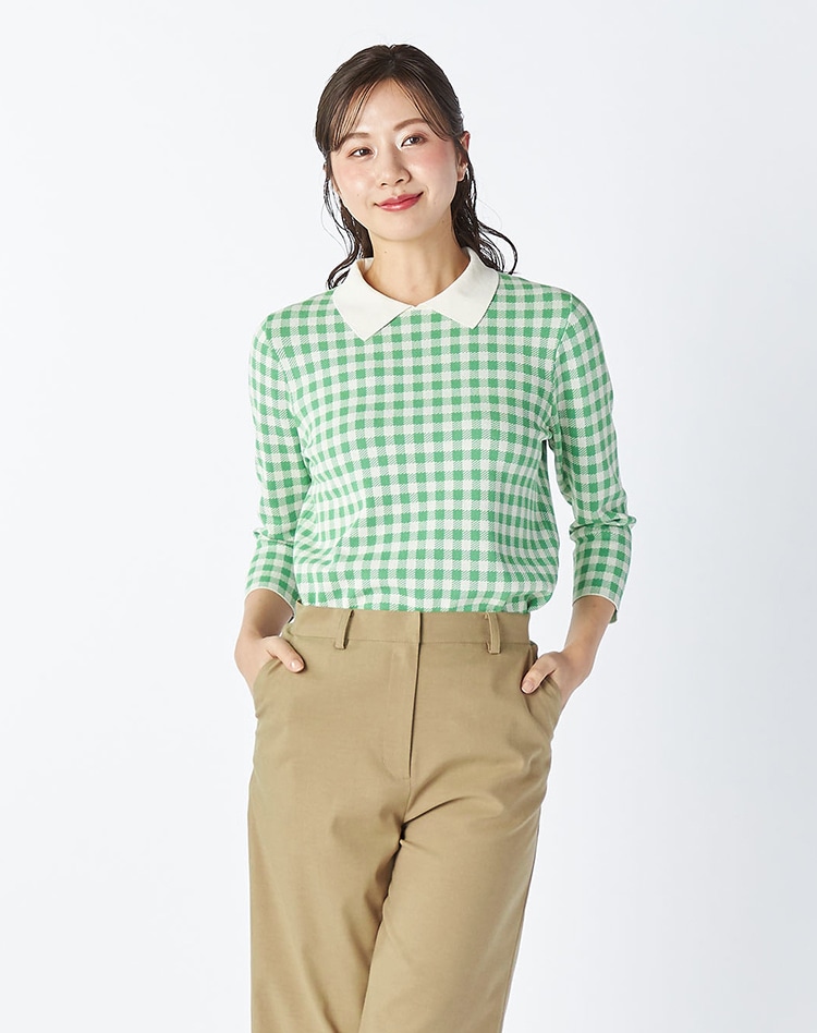 グリーンのチェックニットを身に着けた女性