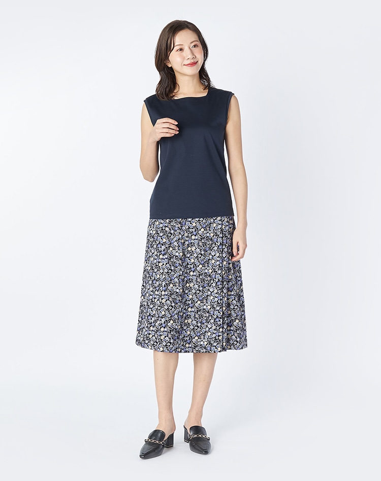 ネイビーのノースリーブとネイビーのスカートを身に着けた女性