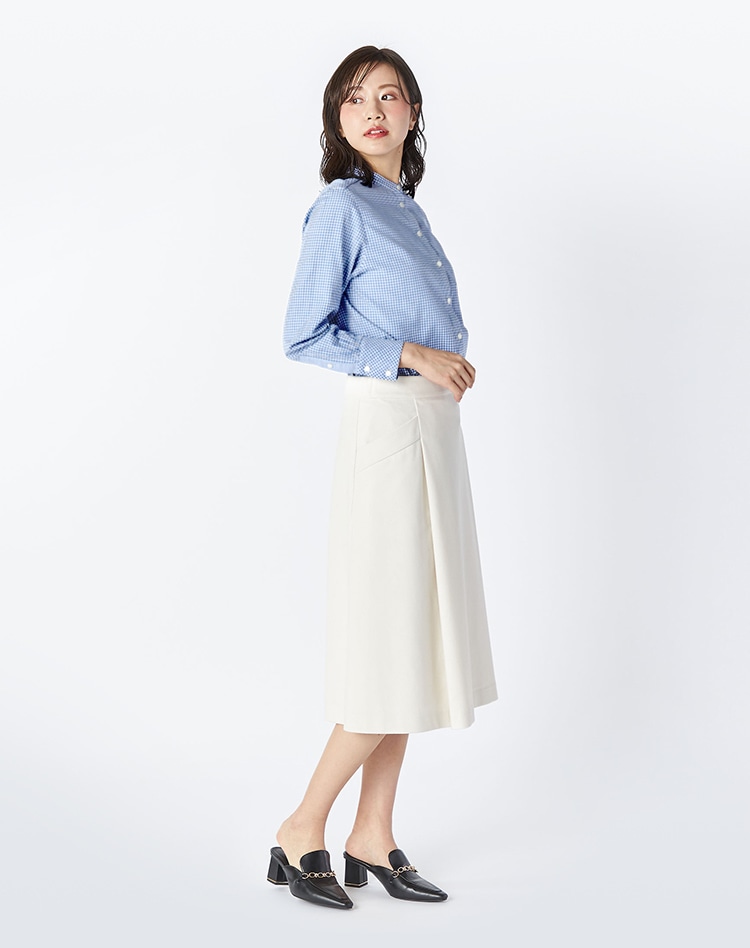 ブルーのチェック柄のブラウスとホワイトのスカートを身に着けた女性