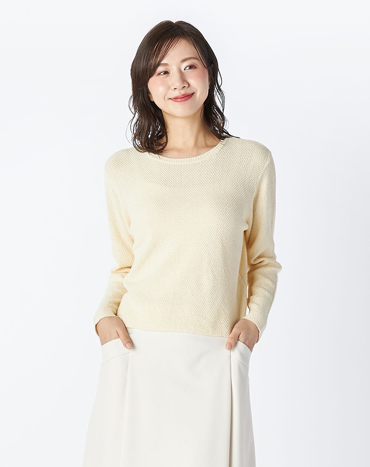 イエローのニットを身に着けた女性