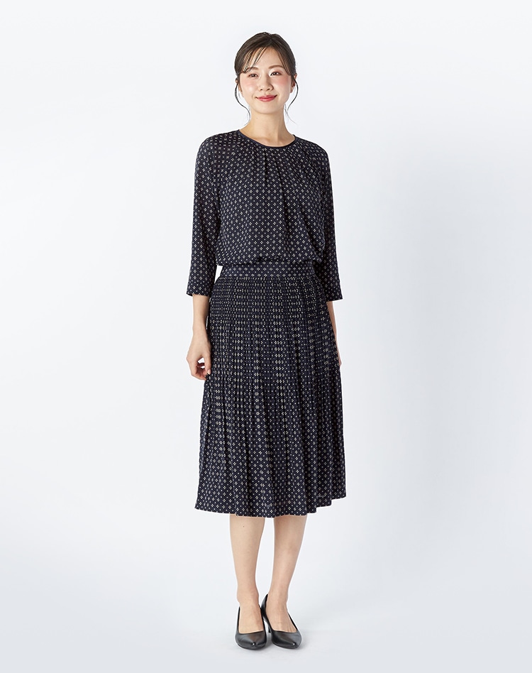 ネイビーの総柄のセットアップを身に着けた女性