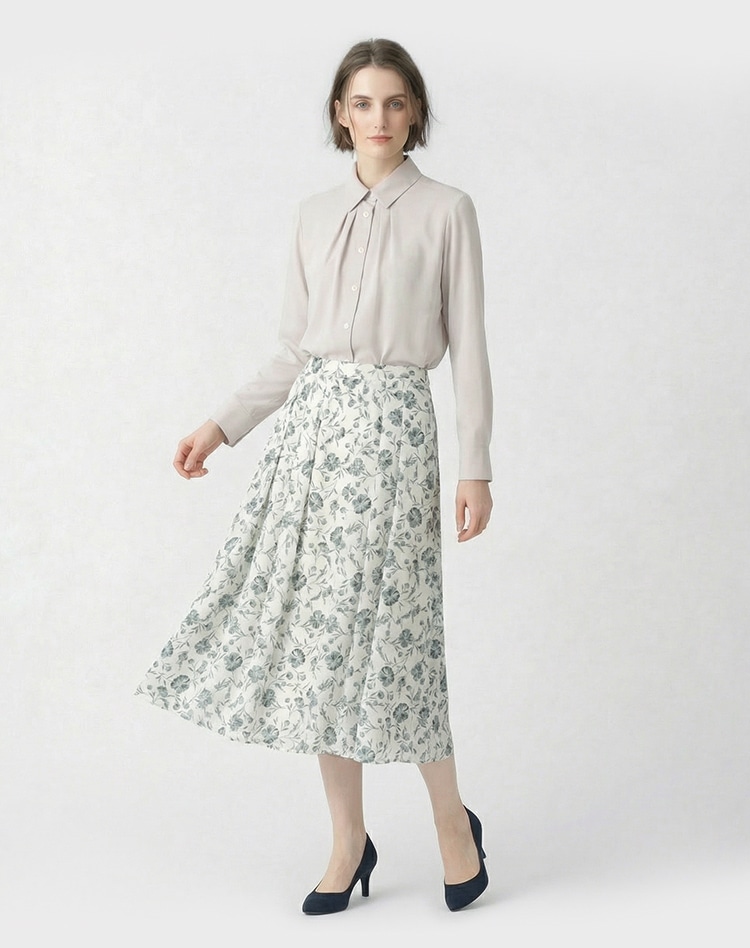 ベージュのブラウスとライトブルーのフラワー柄のスカートを身に着けた女性