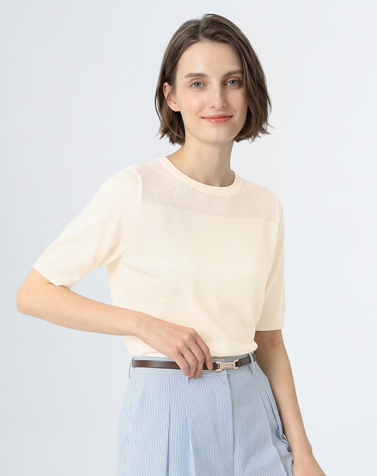 ベージュの半袖ニットを身に着けた女性