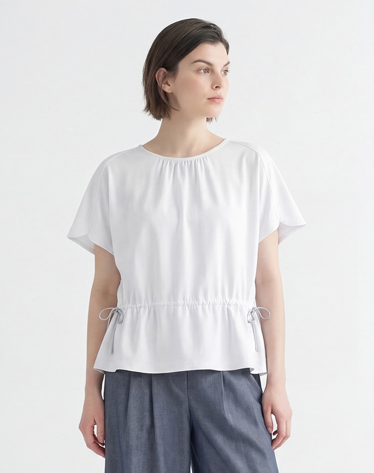 オフホワイトのカットソーを身に着けた女性