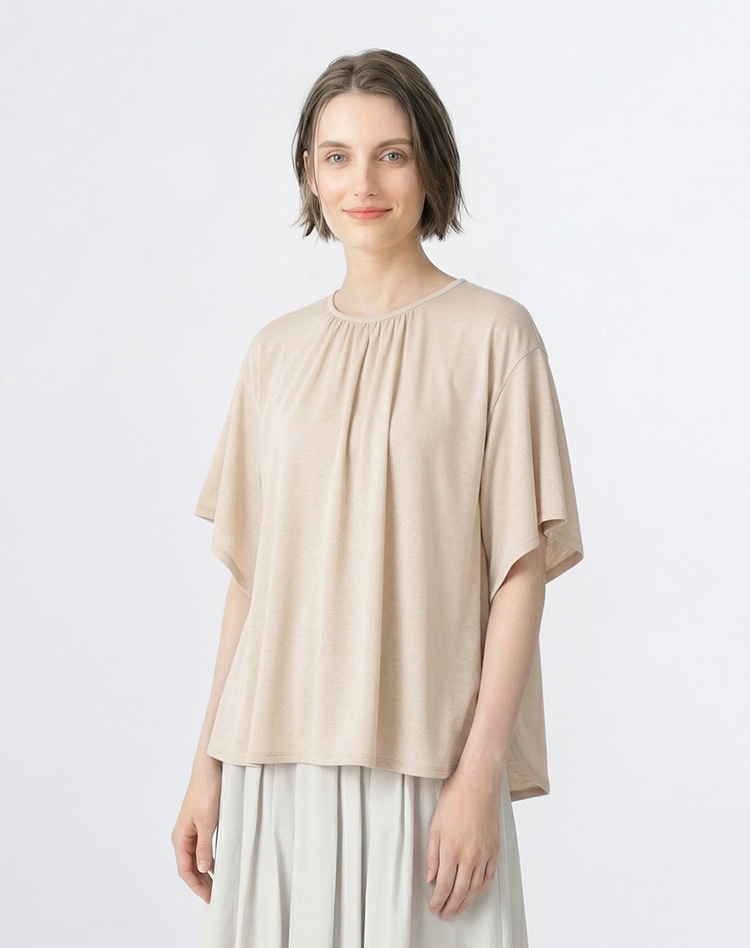 ベージュのシャーリングブラウスを身に着けた女性