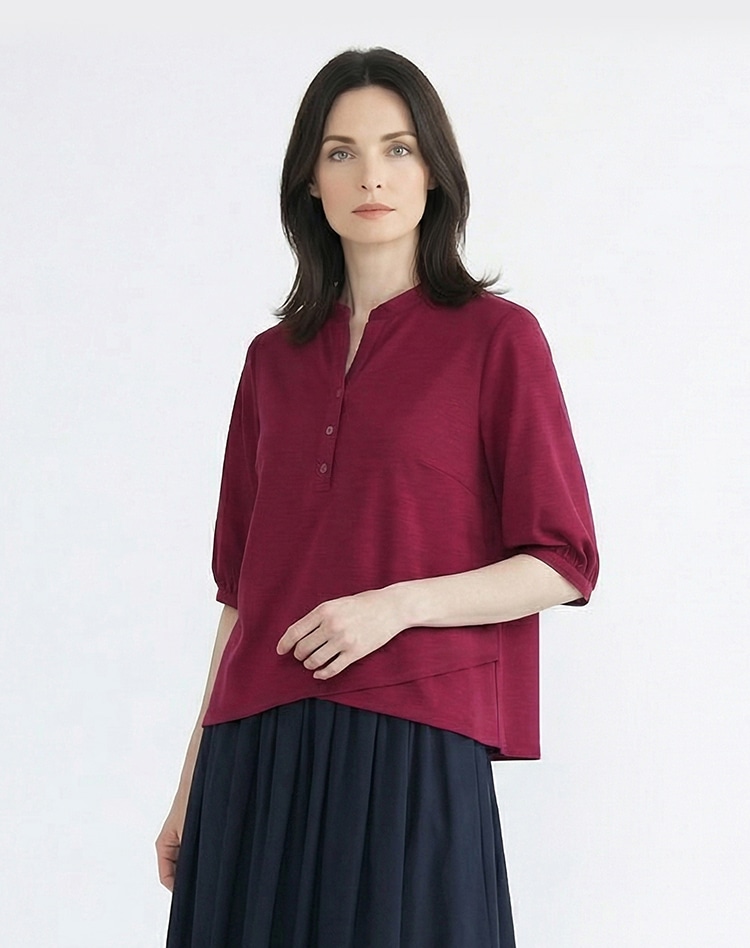 レッドのスキッパーブラウスを身に着けた女性