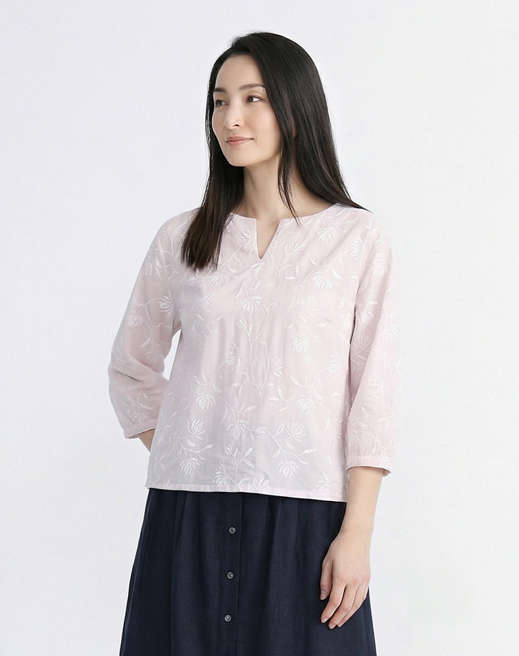 ピンクのフラワー柄のブラウスを身に着けた女性