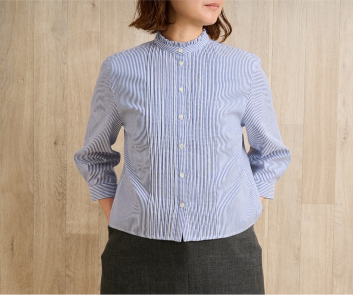 ネイビーのストライプブラウスを着た女性
