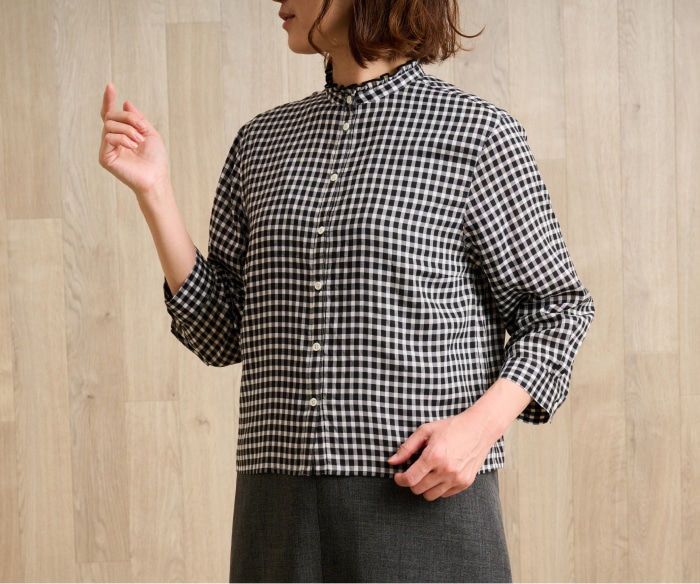 ブラックのチェック柄ブラウスを着た女性