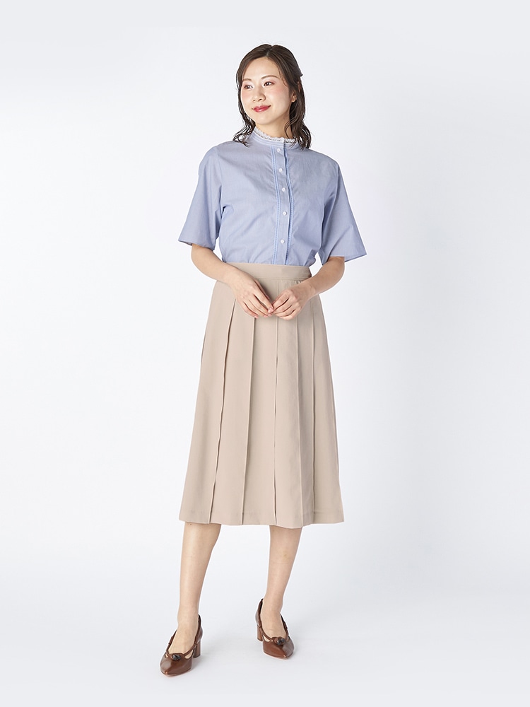 ブルーのブラウスとオフホワイトのスカートを着た女性