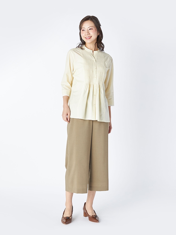 イエローのブラウスとグリーンのパンツを着た女性