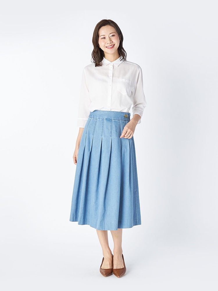 ホワイトのブラウスとブルーのデニムスカートを着た女性