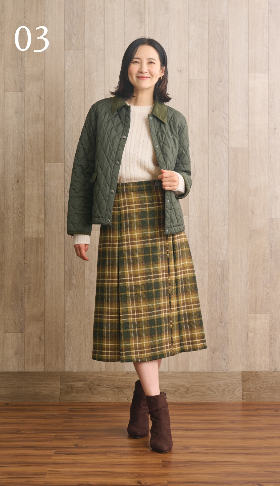 スワローケーブルニットにキルティングジャケットを着用した女性