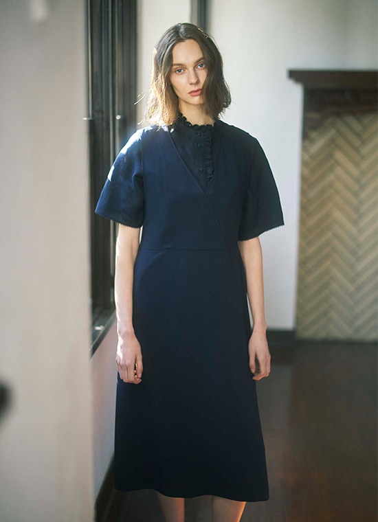 ネイビーのブラウスとワンピースを着た女性